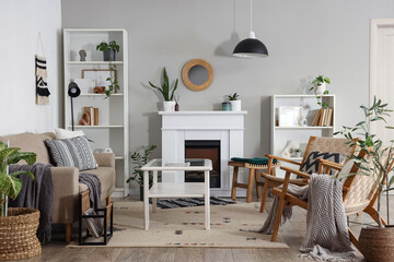 Fototapeta premium Interior of living room with green plants, fireplace and sofa