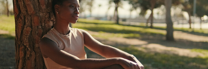 Young woman in casual clothes chilling outdoors among the trees in the park, relaxing in an urban environment and mental health concept. Panoramic. Panoramic © Andrii Nekrasov