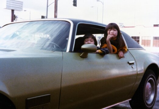 Kids Hanging Out of a 1970s Car Window