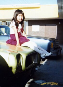 Asian Girl Sitting on Classic Car Hood, 1970s
