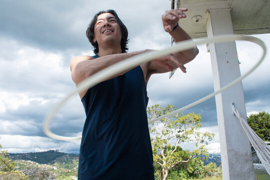 Man Practices Hula Hooping Outdoors Under Cloudy Sky