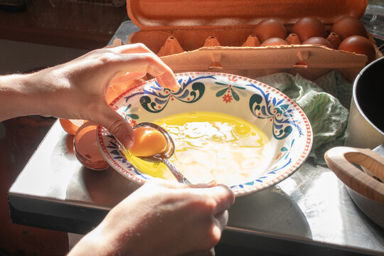 Preparing Eggs in a Colorful Bowl at Kitchen Counter