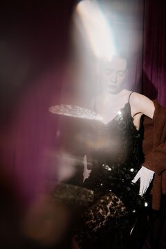 Portrait woman in shiny dress behind dreamy light flares