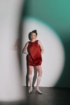 Fashion portrait woman in red dress under neon spotlight