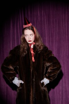 Woman in festive outfit with stern expression - Party hat