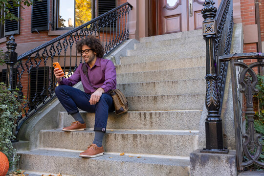 Handsome  black man brownstone sit with cell phone