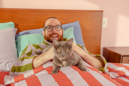 Man with cat in bed