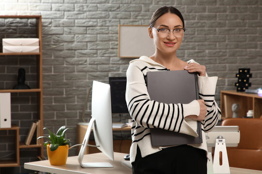 Beautiful young female programmer with laptop in modern office