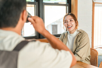 Obraz premium A smiling couple having a conversation while drinking coffee in a cottage, cabin, or log house