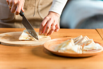 Hot sandwiches in a hot sandwich maker, hands of a woman in an apron cooking sandwiches
