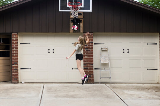 Girl practicing volleyball in her driveway