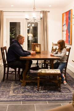 Dad and daghter at a table about to play cards