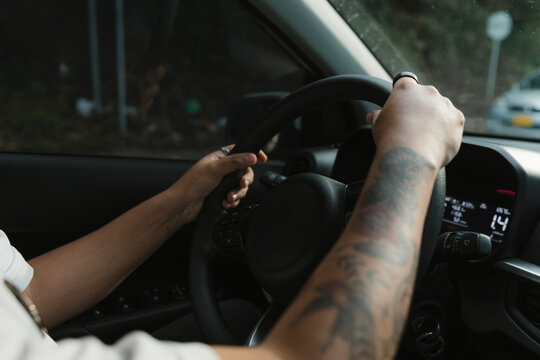 Driver hands on steering wheel inside car