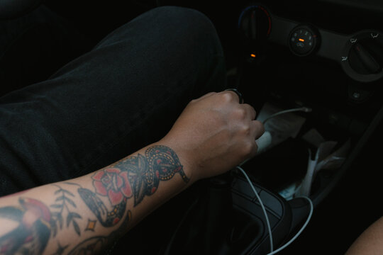 Person driving car holding gear shift lever