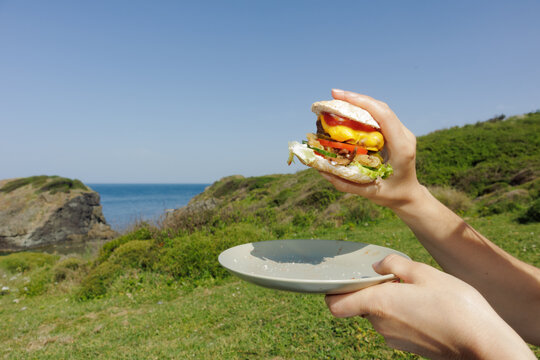 A young woman eats a burger
