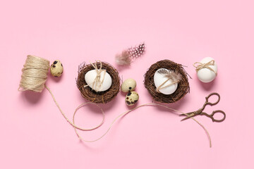 Fototapeta premium Easter eggs with feathers, rope and scissors on pink background