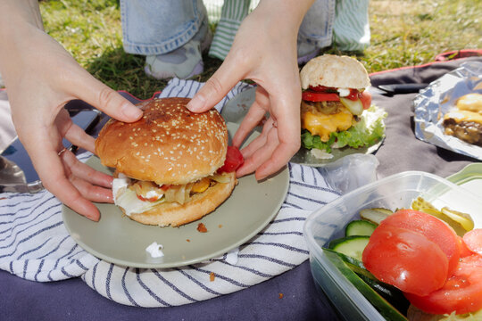 A young woman is making a burger
