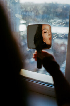 Woman Looking Into Hand Mirror