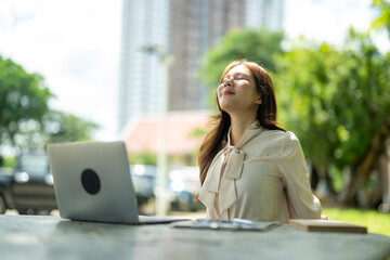 Fototapeta premium Woman relaxing outdoors with laptop enjoying fresh air