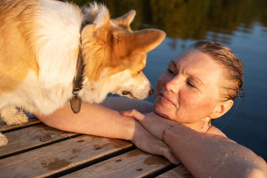 Woman and Dog Sharing a Gentle Moment by the Lake
