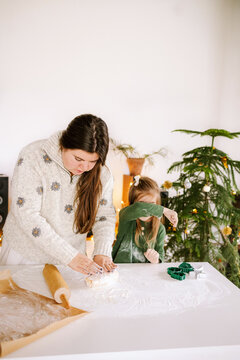A woman and a child are rolling out the dough.