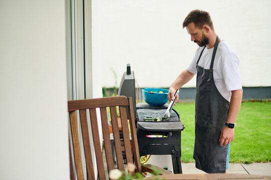 Man Grilling Vegetables on Backyard Patio