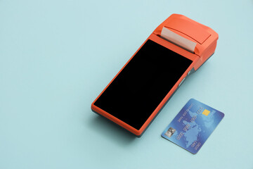Payment terminal with credit card on blue background