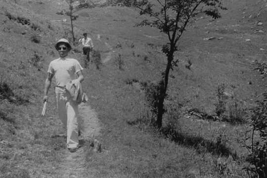Man Walking Along a Hillside Path in a Black and White Film Photo