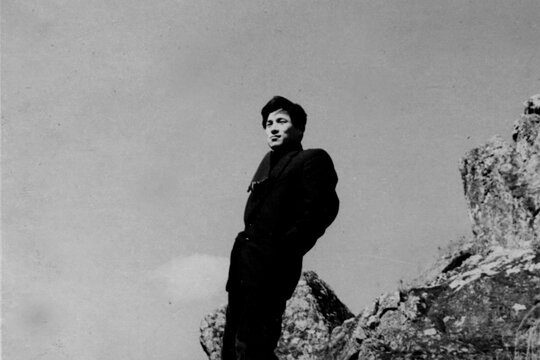 Man Standing on Rocky Landscape in a Black and White Film Portrait
