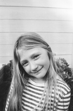 A Black and White Film Image Of a Girl With Long Hair Smiling 