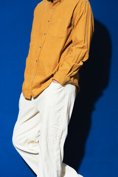 Model in Mustard Shirt Against Blue Backdrop