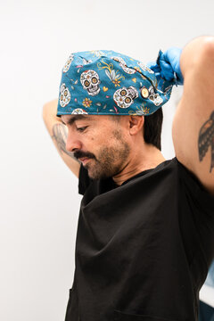 Veterinarian man tying surgical cap for work