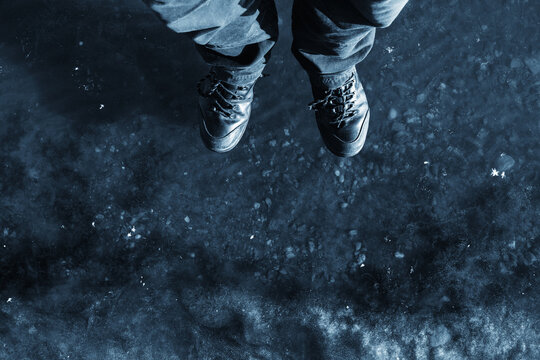 Feet standing on frozen lake