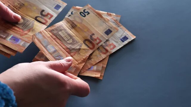 Women Earnings in the European Union. female hands counting euro banknotes on gray blue background. 4k footage