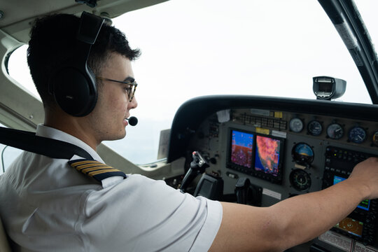 Pilot adjusting cockpit instruments