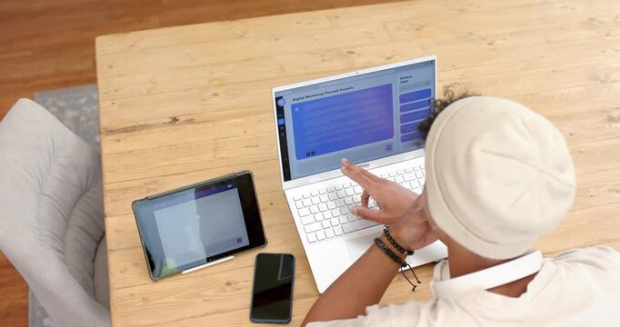 Right hand is tapping laptop trackpad on wooden table while leaning forward, navigating web app