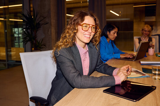 Smiling woman sits at the meeting table