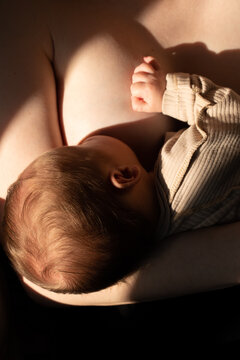 Newborn breastfeeding in mother&rsquo;s arms close up