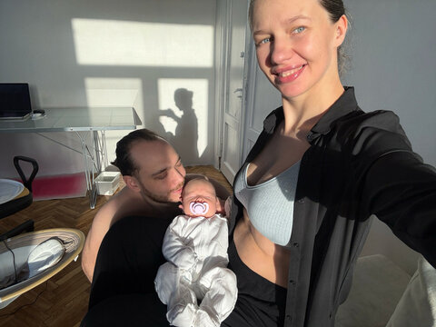 Family moment in sunlight with newborn baby