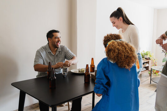 Friends laughing as they set the table