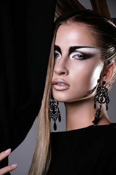Model Poses Near Curtain With Dramatic Makeup in Studio