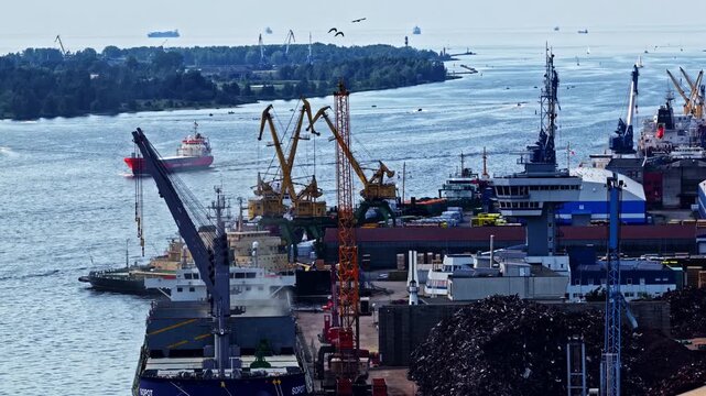 Panoramic aerial overview of a large shipyard on the bank of a estuary.
