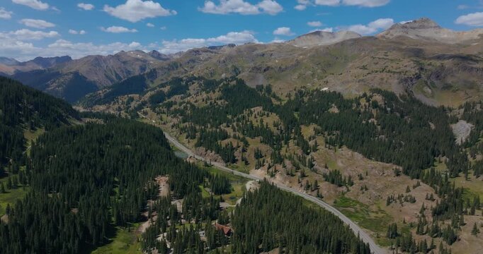 Aerial of mountain highway weaving by rugged San Juan alpine landscape, Million Dollay Highway Colorado USA