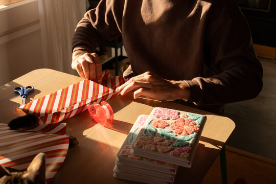 Man wrapping gift with cat