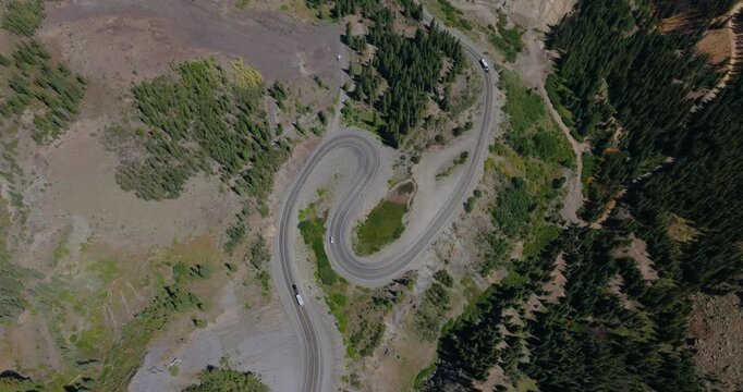 Top down aerial of tight mountain hairpins winding by rugged San Juan alpine terrain, Million Dollay Highway Colorado USA