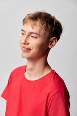 Smiling young man wearing a red casual shirt in a studio setting with soft lighting, relaxed pose and friendly vibe, suitable for lifestyle, fashion or editorial projects.