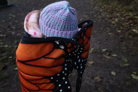 Toddler wearing butterfly wings outside