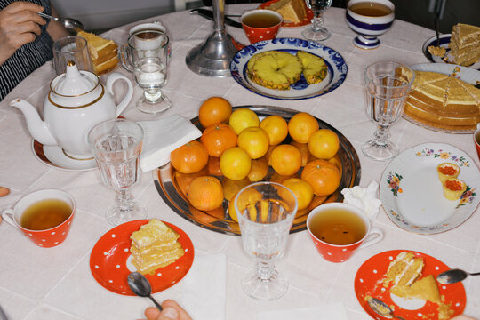 Gathering Around a Table With Tea and Snacks in a Home Setting