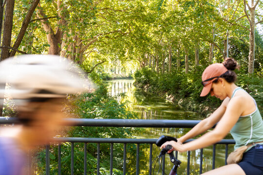 Cyclists Passing Over Canal Bridge