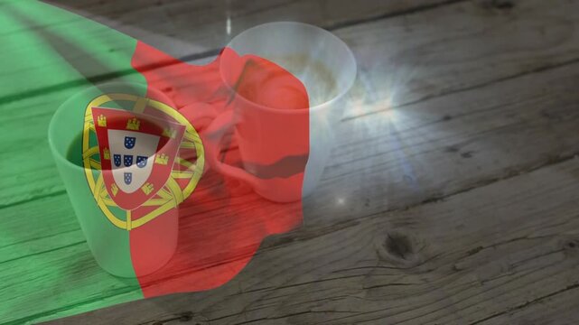 Portuguese flag overlay appearing from left, billowing across two mugs and revealing tabletop grain